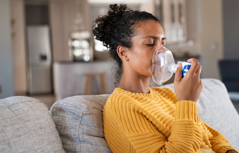 A woman using a nebuliser at home.