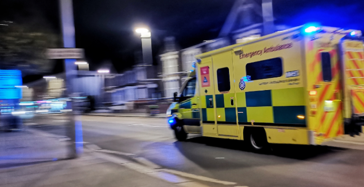 An ambulance racing down a residential street