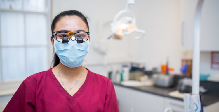 Woman in red scrubs wearing PPE