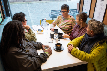 A group of women sitting around a table in a cafe